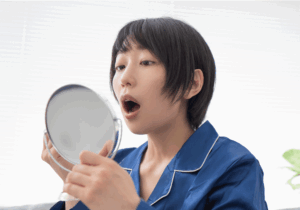 口の中をみている女性
