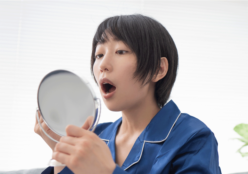 口の中をみている女性