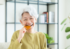 せんべいを食べる高齢女性